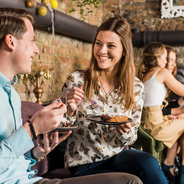 Un homme et une femme dégustent un gâteau lors d'un événement dans une salle à Montréal.