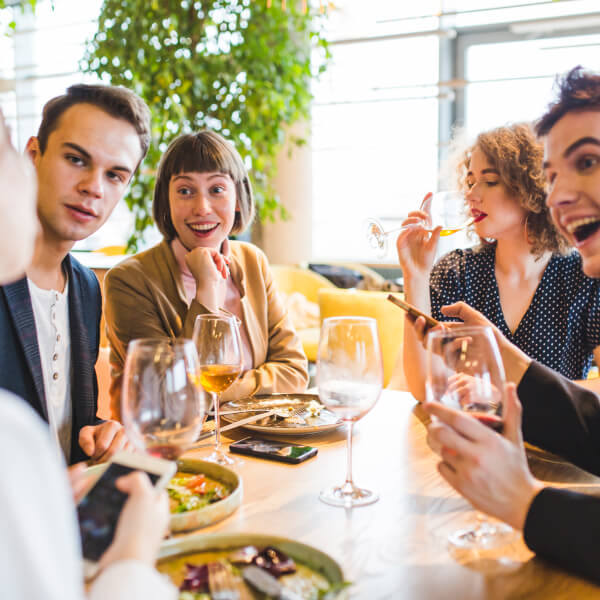 Un groupe de personnes assises à une table, dégustant du vin lors d'un événement convivial.